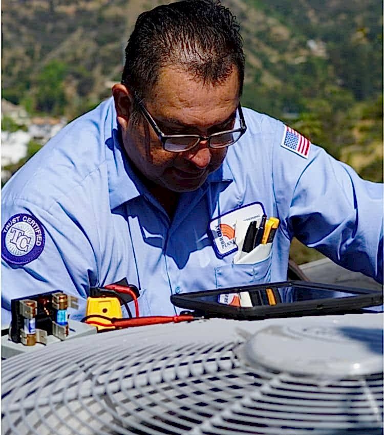 Image of a technician on a Beverly Hills house performing an AC maintenance service