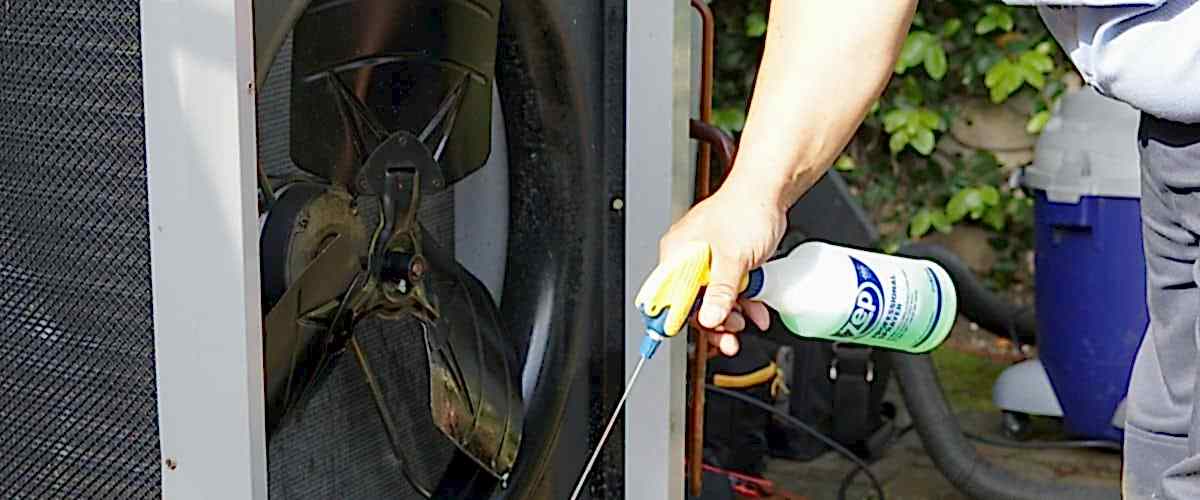 Image of a Brody Pennell AC technician cleaning an air conditioner