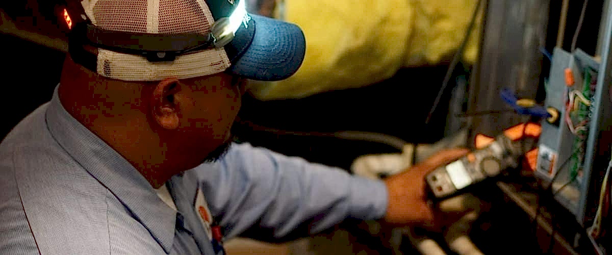 Image of a Brody Pennell heater service technician conducting routine maintenance on a Carrier furnace.